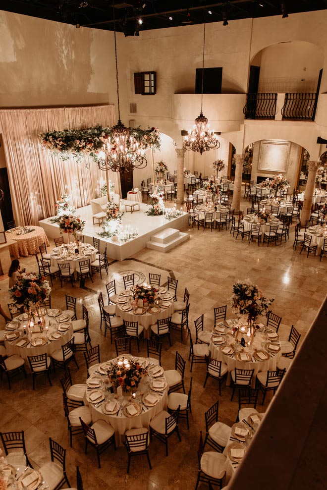 The venue's reception space is decorated with floral centerpieces, floral instillations and candlelight. 