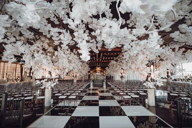 The ceremony space at the Houston wedding venue is detailed in white floral instillations.