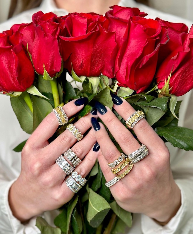 The model wears a variety of wedding bands from Zadok Jewelers while holding a bouquet of roses. 