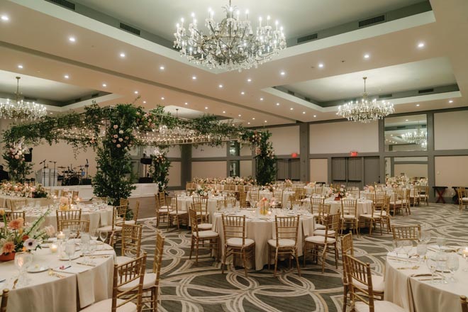Spring colored florals, greenery and twinkling lights decorate the ballroom of the Omni Houston Hotel.