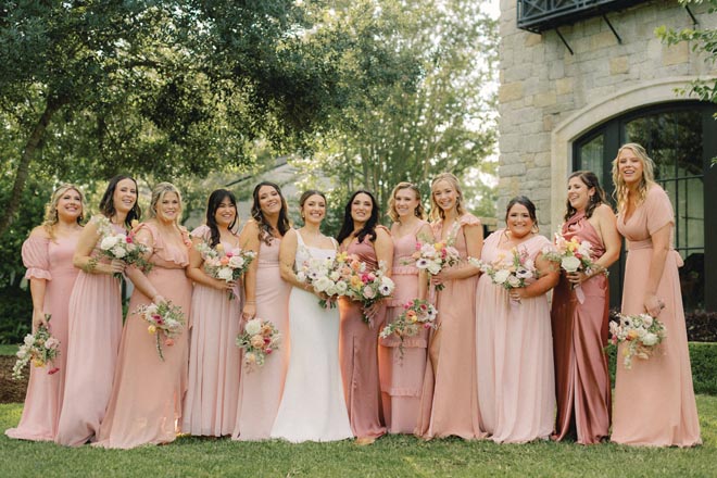 The bridesmaids wear blush colored dresses for the springtime garden wedding at the Omni Houston Hotel.
