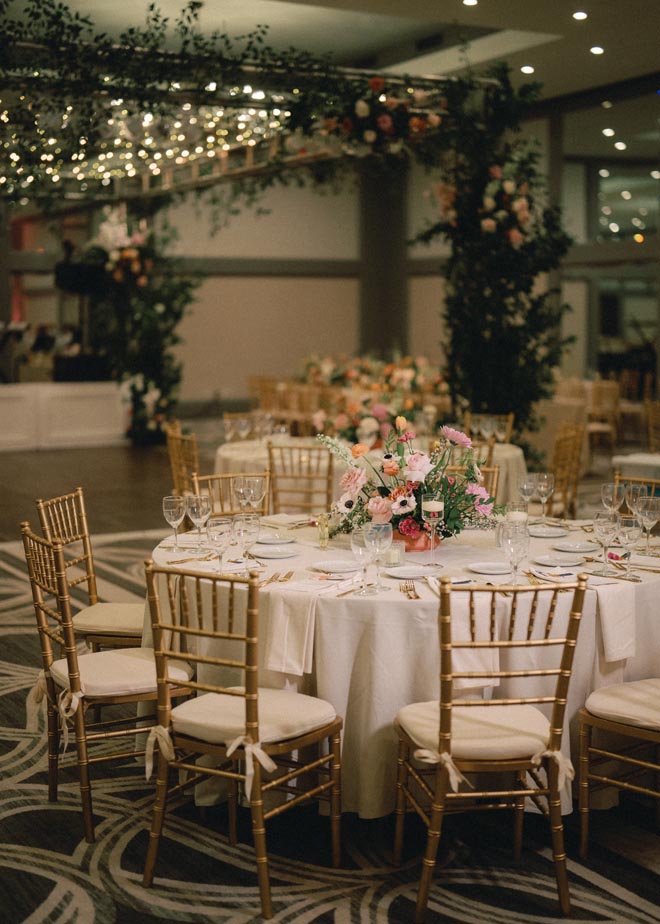 Pink, orange, white and peach florals decorate the reception tables in the ballroom at Omni Houston Hotel.