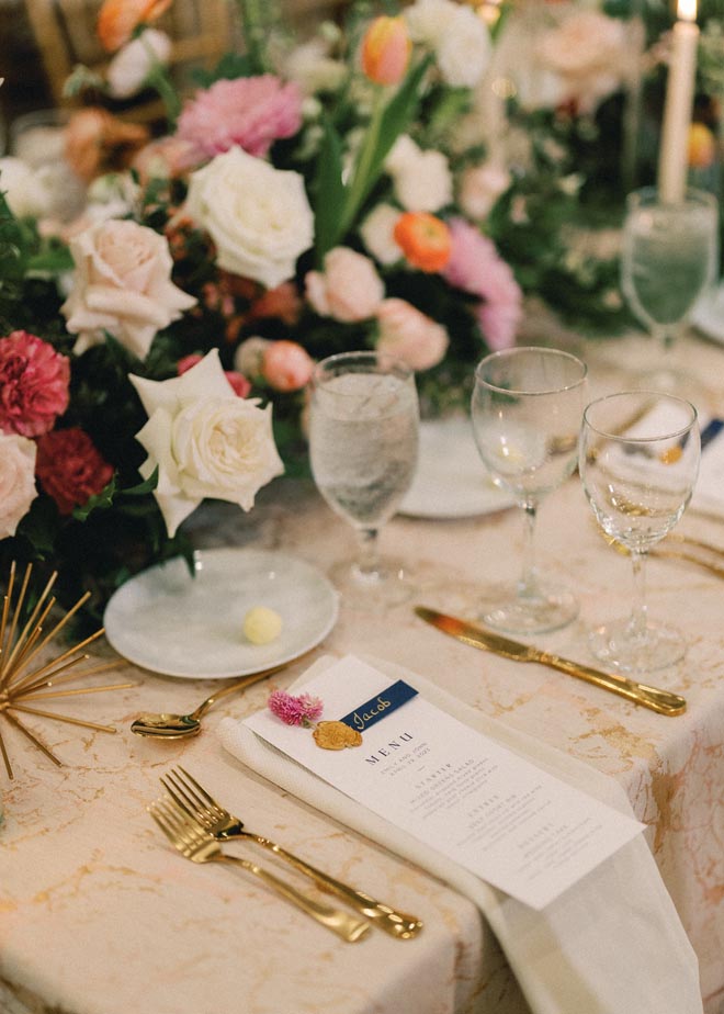 White roses and orange and pink florals detail the spring garden affair.