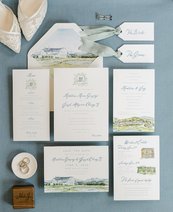 A blue and white invitation suite with drawings of the Park City mountains.