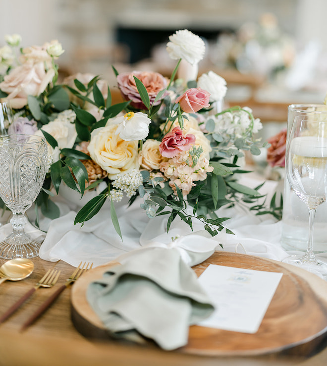 A floral centerpiece with greenery, yellow and pink florals. 