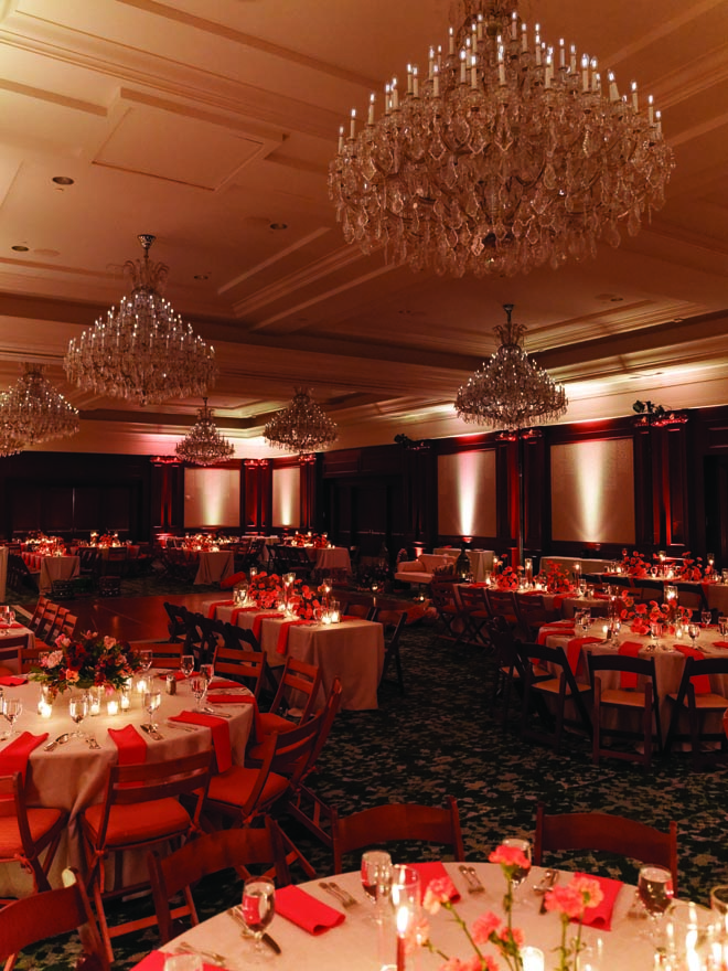 Red decor and candles decorate the ballroom for the bride and groom's sangeet. 