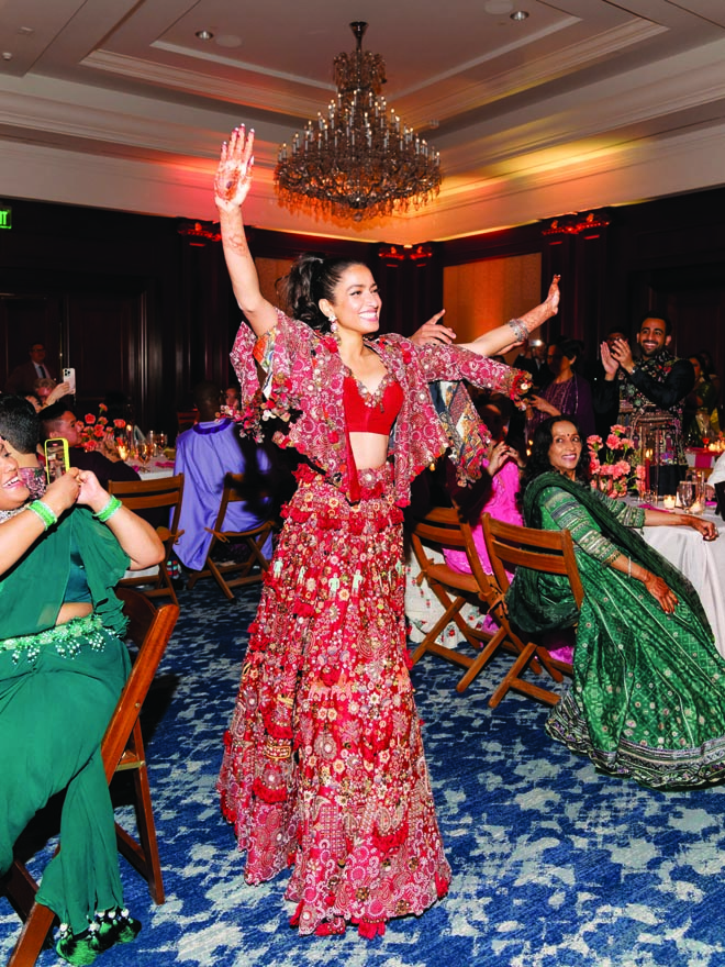 The bride dances in traditional Indian wedding attire at her sangeet. 