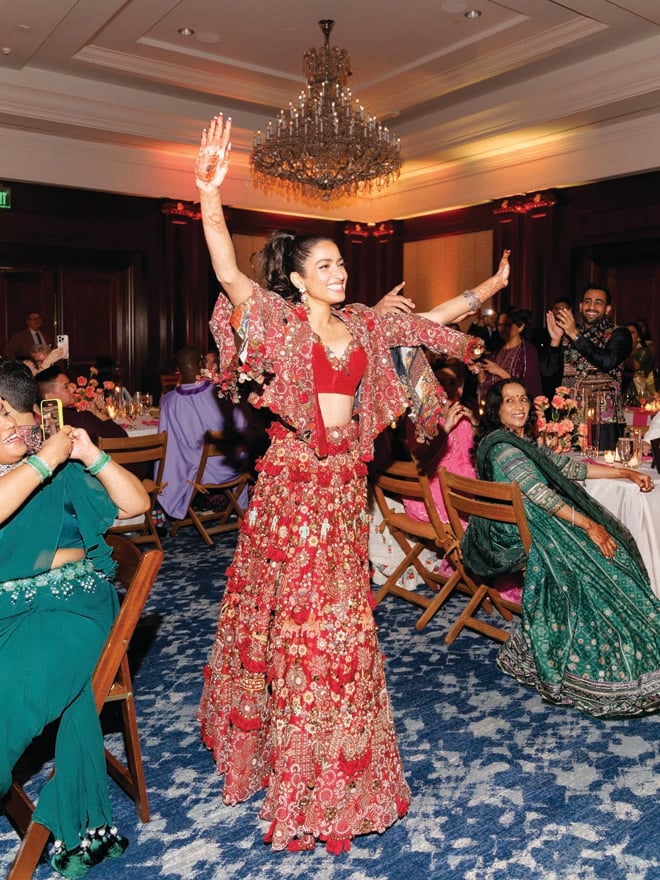 The bride dances in traditional Indian wedding attire at her sangeet. 