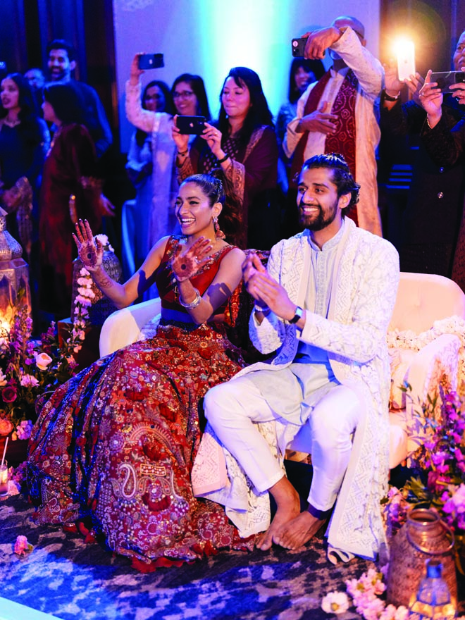 The bride and groom celebrate with friends and family at the sangeet ceremony at their destination wedding in Malibu.