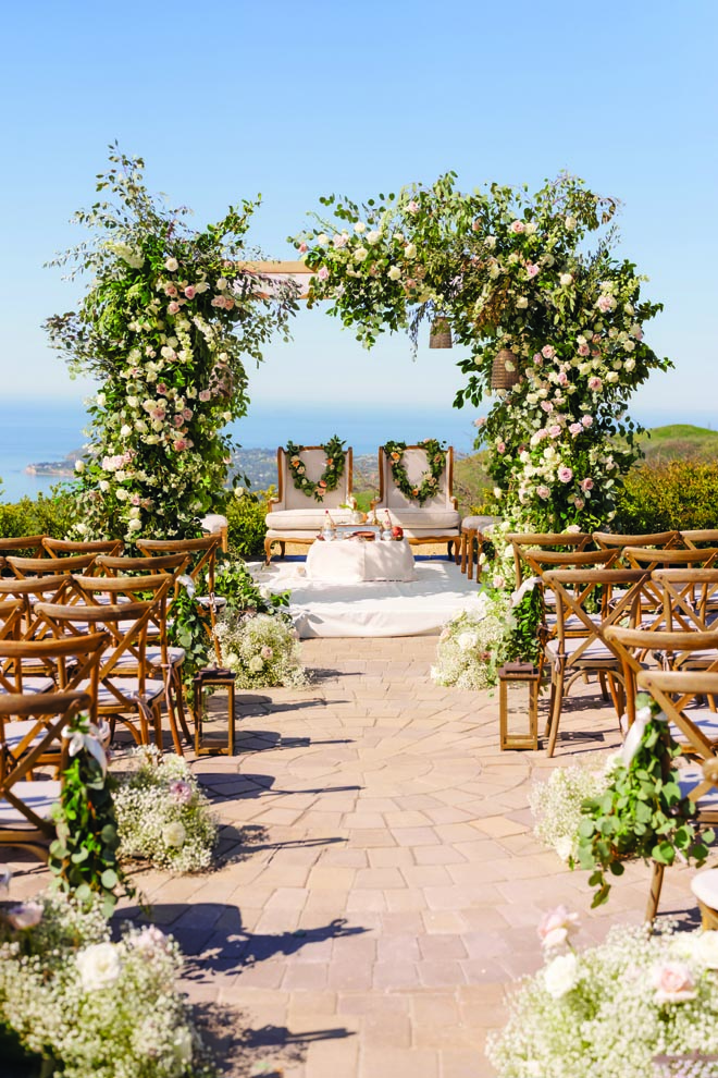 Floral arches with greenery and white and pink florals decorate the alter for the sahaadi ceremony.