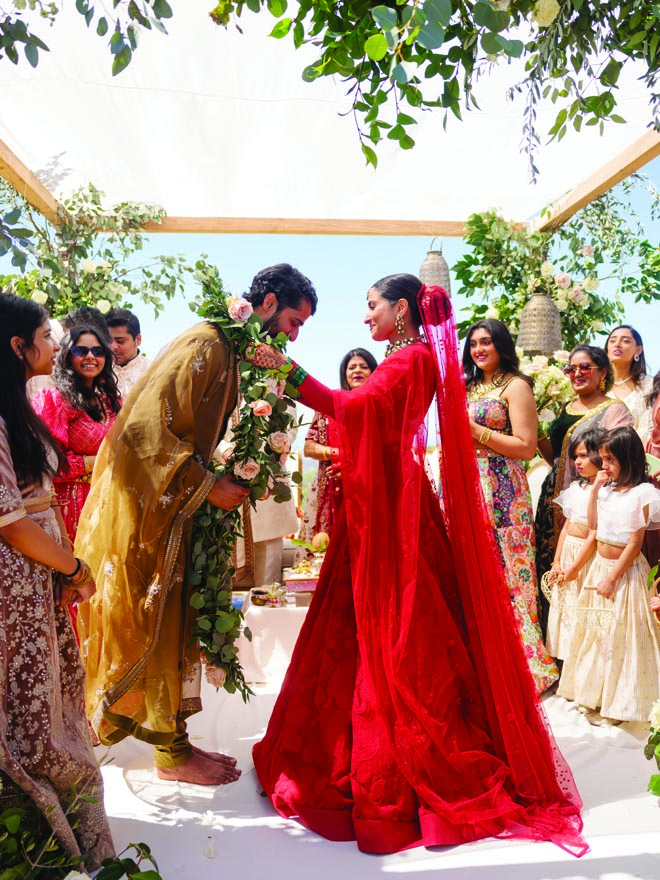 The bride and groom exchange floral garlands at their sahaadi ceremony. 