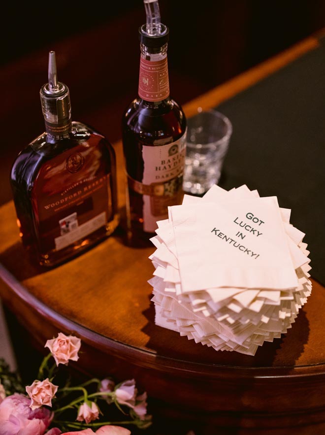 Bottles of bourbon with napkins that say "Got lucky in Kentucky."