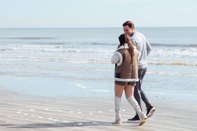 The couple walk along the beach to a heart made out of seashells for their dream proposal.
