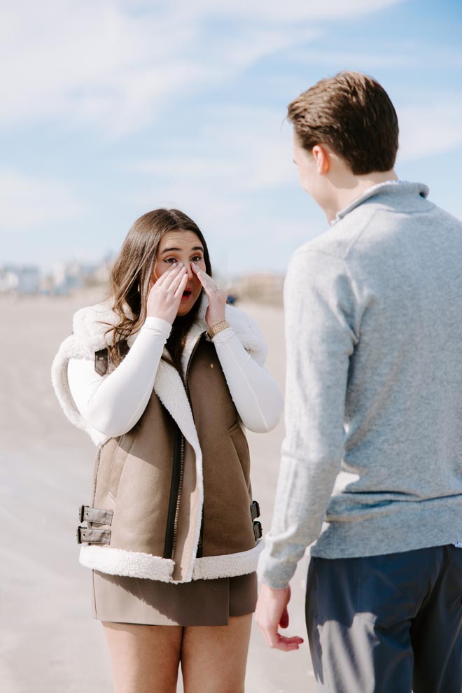 The girl cries after saying "yes" to her dream proposal on the beach in Galveston. 