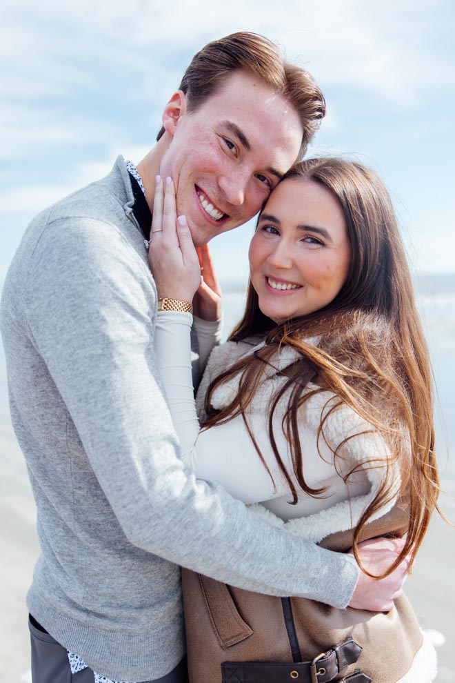 The couple smile while hugging after their dream proposal in Galveston.
