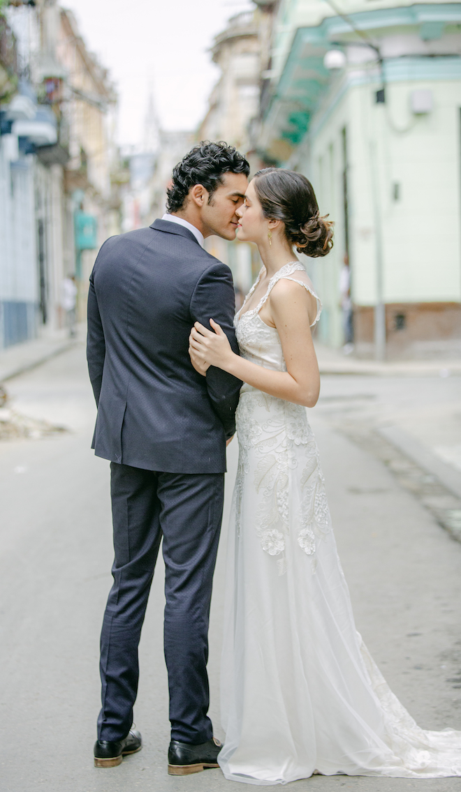 A bride and groom about to kiss in the streets of Havana. 