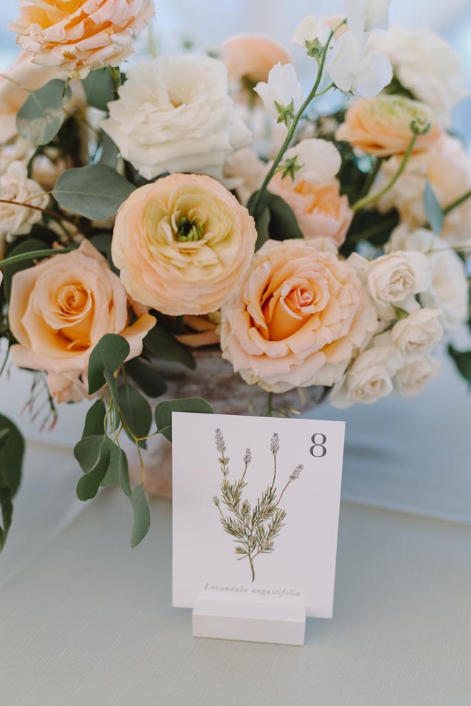 Sage, peach and orange floral centerpieces decorate the reception tables at Omni Barton Creek Resort and Spa.