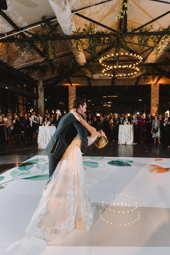 The bride and groom dance at their sage, peach and orange wedding reception in the Texas hill country.