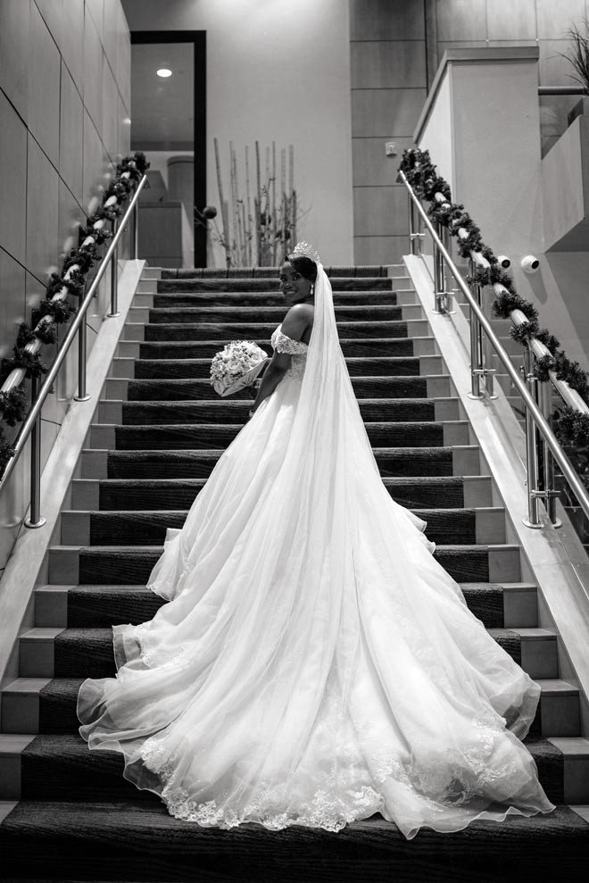 The bride stands on the stairs before her wedding ceremony in Houston.
