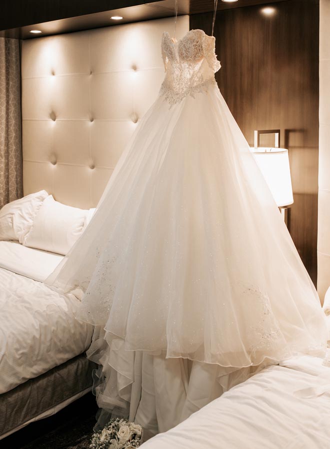The bride's wedding dress hangs in a Houston hotel while getting ready.