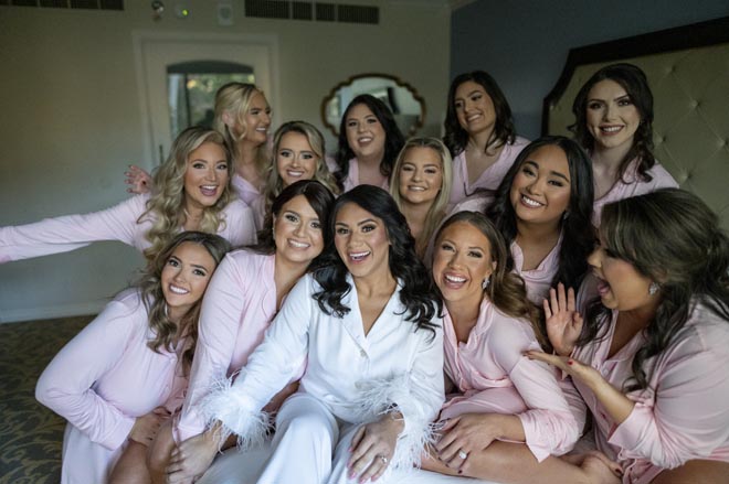 The bride and her bridesmaids getting ready for the wedding reception in matching pajamas. 