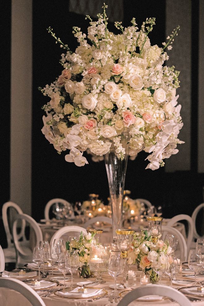 Floral centerpieces with roses and greenery decorate the reception tables.