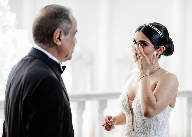 The bride wipes her tears away during her first-look with her father. 