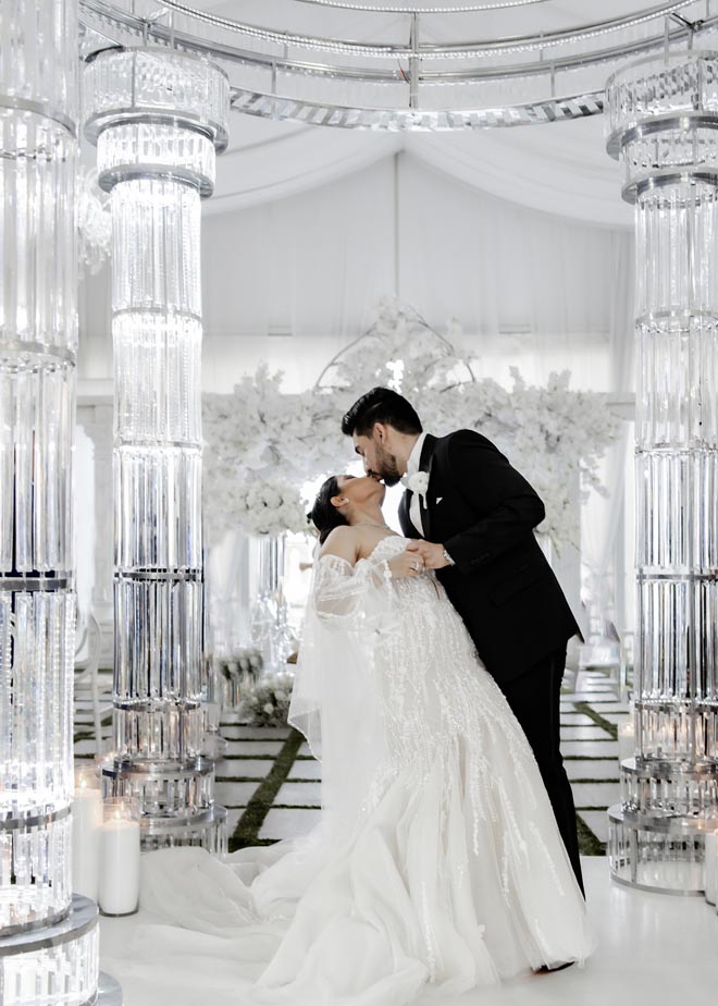 The bride and groom share a kiss at their wedding venue, the Sans Souci Ballroom.