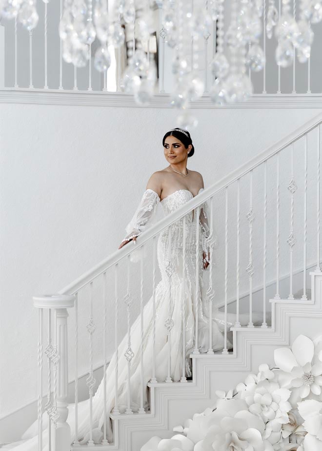 The bride stands on the staircase at the wedding venues, Sans Souci Ballroom. 