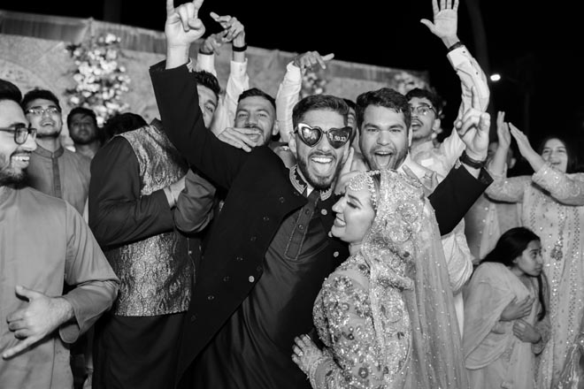 The bride and groom celebrate with wedding guests at their pastel Gulf Coast wedding. 