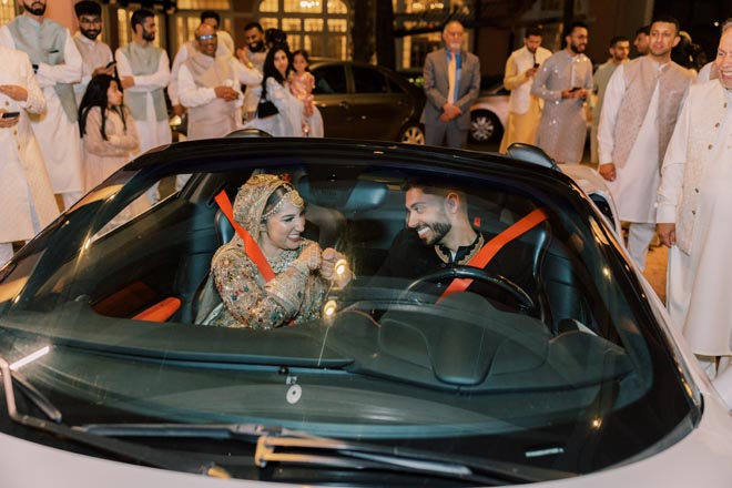 The bride and groom exit their pastel Gulf Coast wedding at the Grand Galvez in a Ferrari.