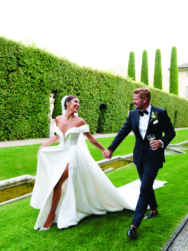 The bride and groom hold hands outside their Italian wedding venue, Villa Balbiano. 