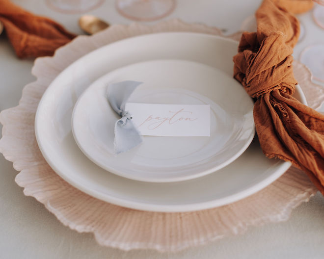 A pink, white and orange place setting with a name tag reading "Payton" on it. 