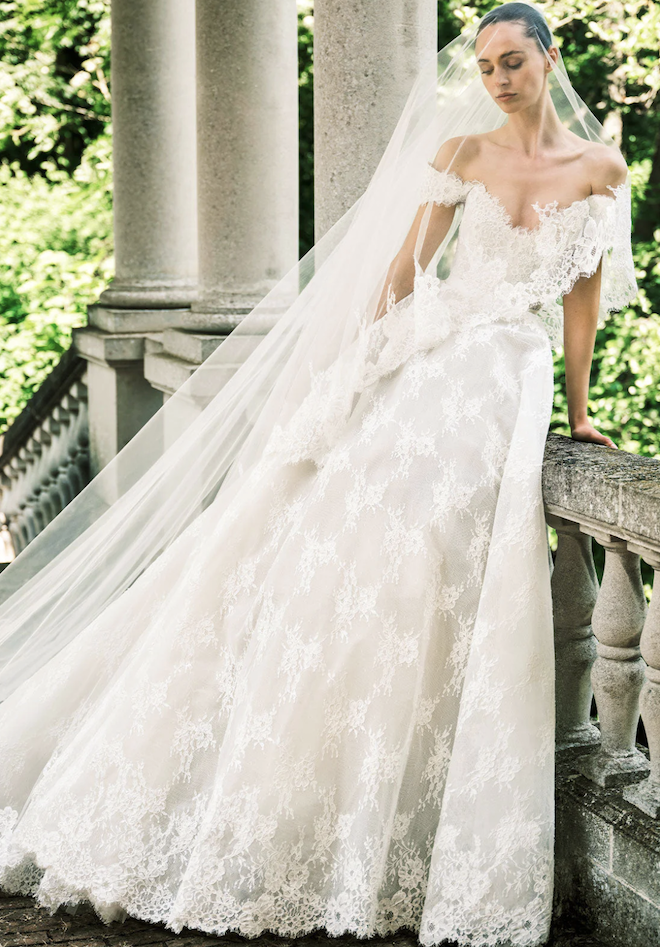 Model wearing an all lace gown with a matching veil. 