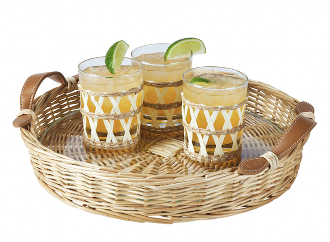 A wicker drink tray with three cocktails on it. 