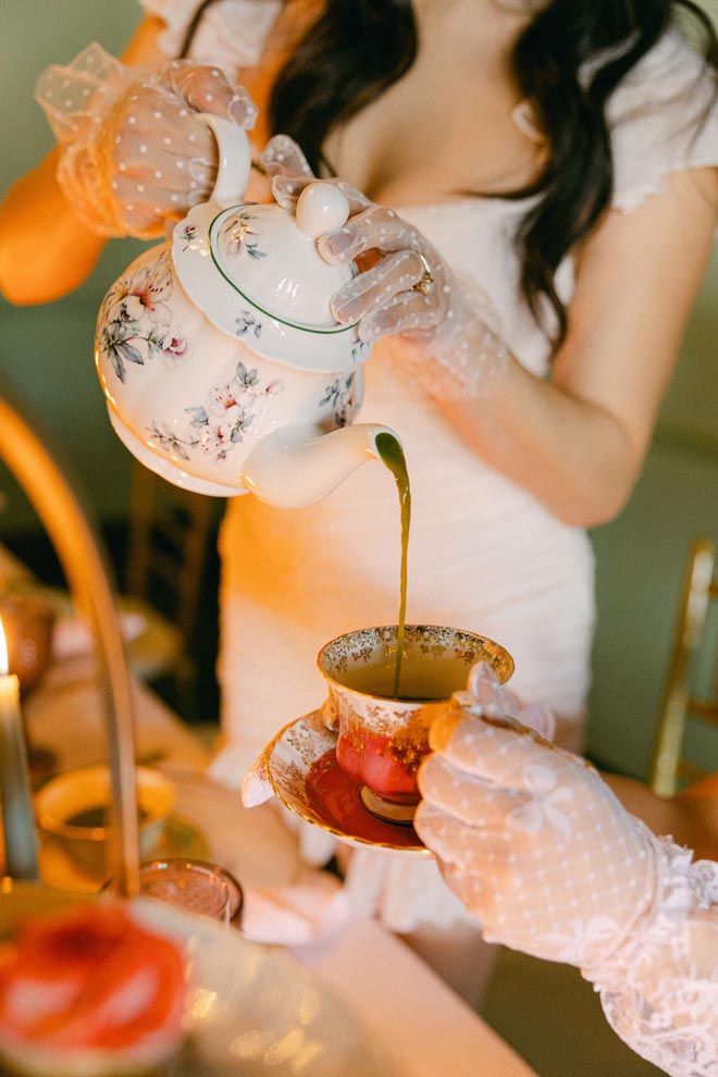 The bride pours tea into a tea cup. 