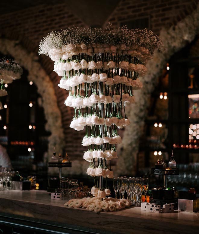 White roses hang from the bar at Broadway-styled wedding reception at The Astorian.
