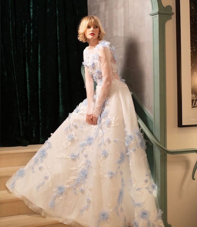 A long-sleeve tulle ballgown with blue floral embellishments. 