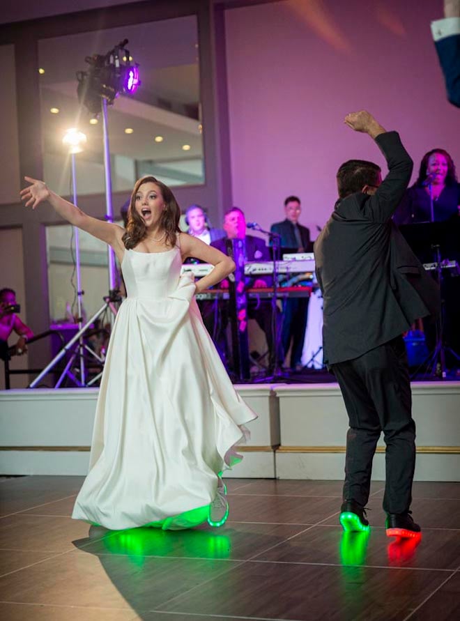 The bride and her father wear matching light up sneakers for their father-daughter dance. 