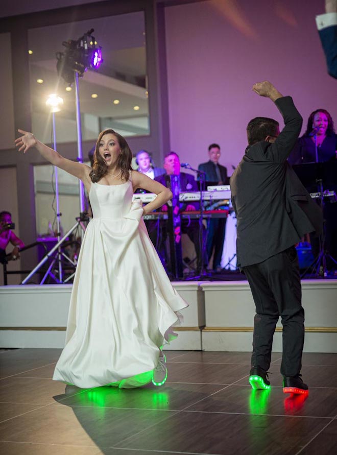 The bride and her father wear matching light up sneakers for their father-daughter dance. 