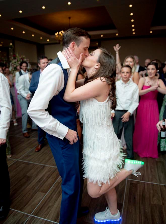 The bride and groom share a kiss on the dance floor at their ballroom wedding in Houston.