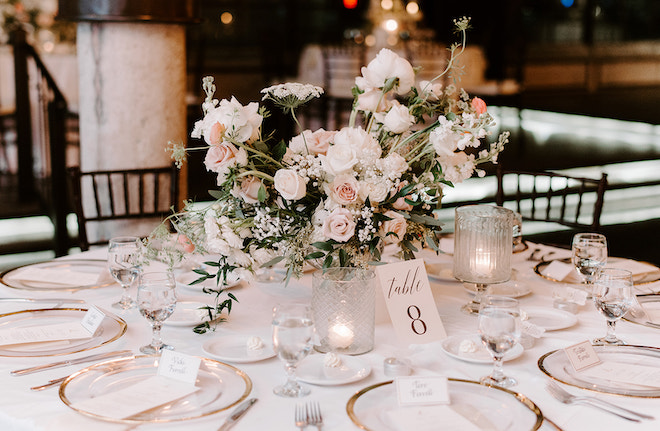 Pink and white floral centerpieces decorate the reception space at The Astorian.