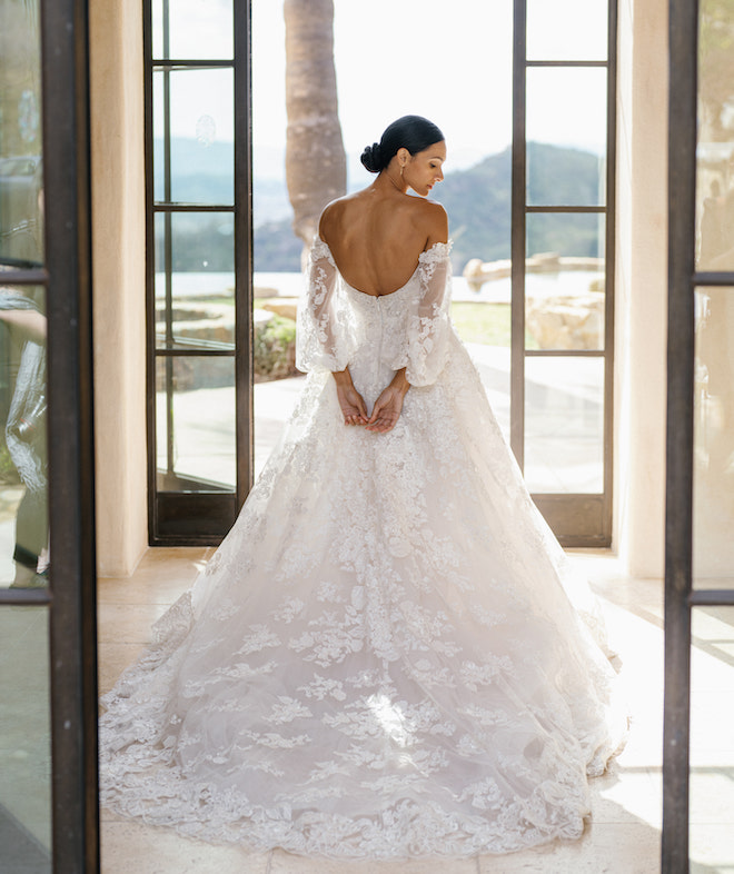 The bride in a off-the-shoulder lace gown by Monique Lhuillier. 