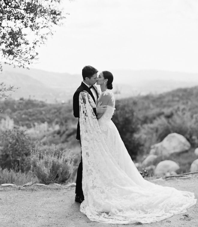 The bride and groom kissing against the mountains in Ojai California. 