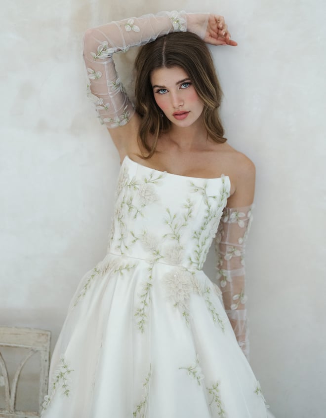 Strapless wedding gown with green and cream floral details.