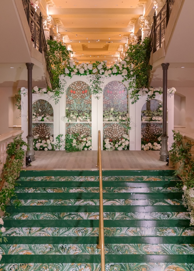 Green printed stairs and a wall with green floral print.