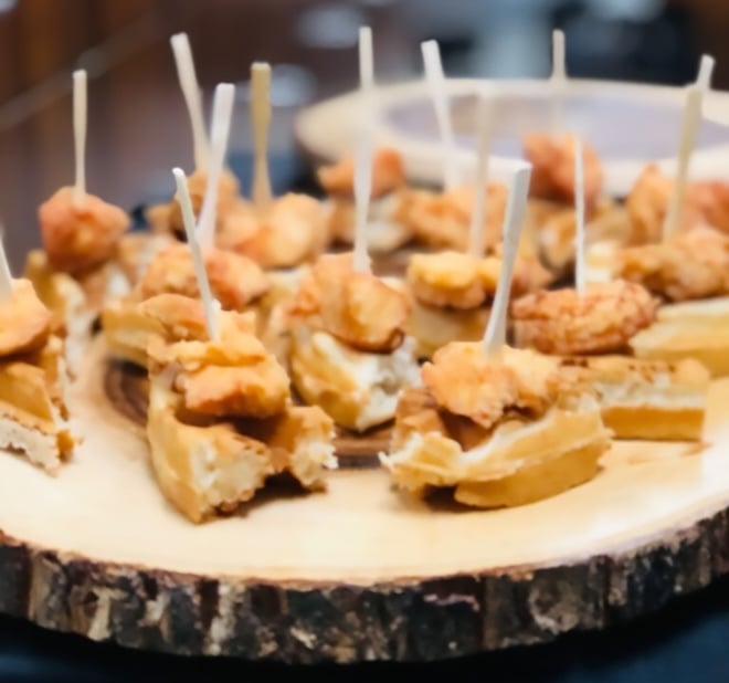Waffles with chicken bites served as a passed appetizer.