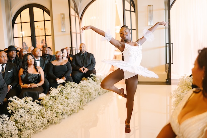 A ballerina dancing down the aisle.