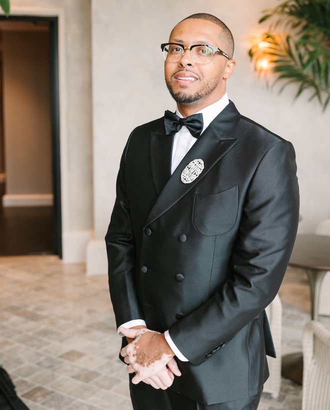 The groom smiling in his suit before the ceremony.