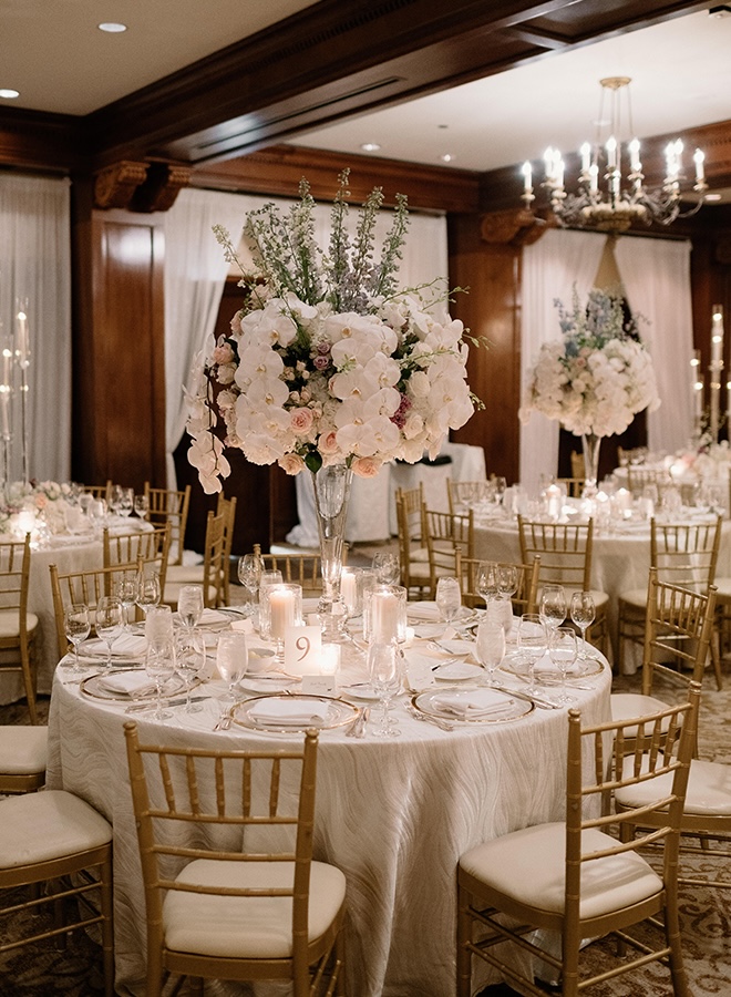 Floral arrangements with orchids and champagne and lavender decor decorate the reception tables in the ballroom.